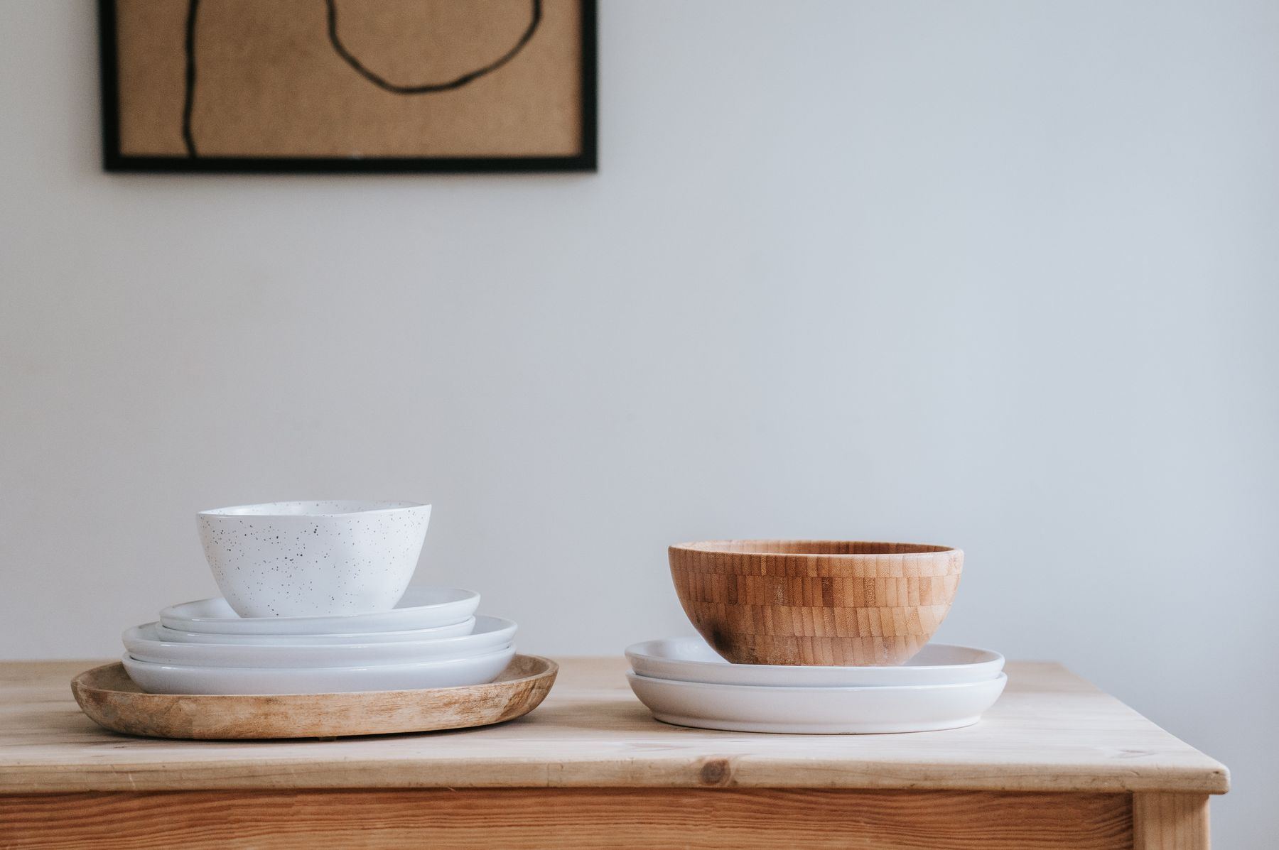 Platos de gres blanco apilados sobre una mesa de madera