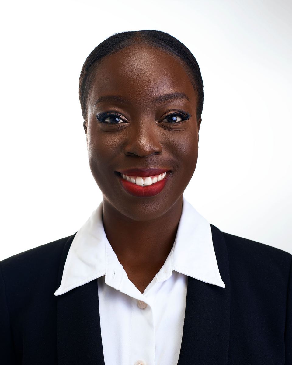 Retrato de una mujer sonriente con blazer oscuro y camisa blanca